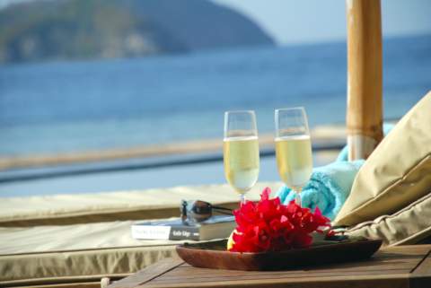 two refreshing glasses of champagne on a sunbed