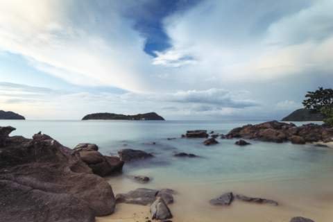 Calming flat ocean view from rocky beach